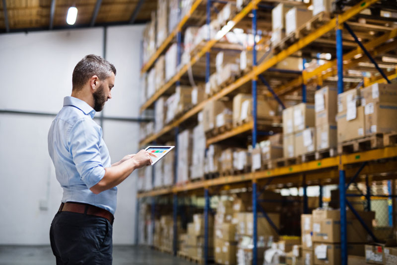 person in a warehouse with an ipad